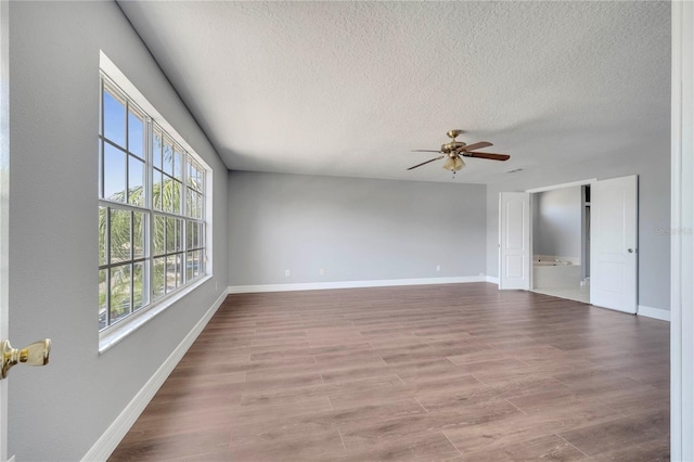 5768 Los Palma Vista Dr, Orlando, FL 32837 - empty room featuring a textured ceiling, a ceiling fan, baseboards, and wood finished floors