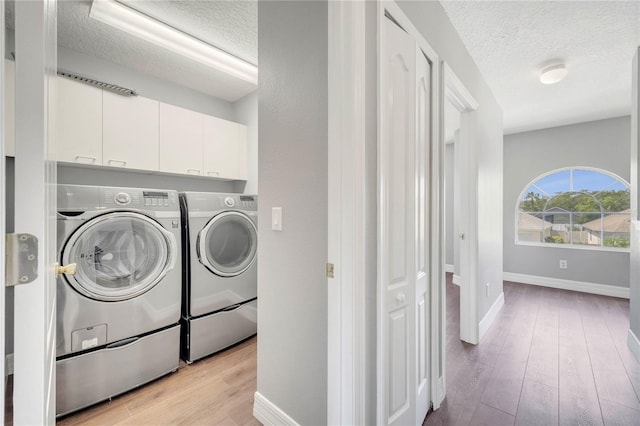 5768 Los Palma Vista Dr, Orlando, FL 32837 - washroom featuring washer and dryer, a textured ceiling, cabinet space, light wood-style floors, and baseboards