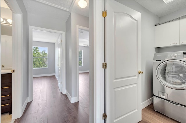 5768 Los Palma Vista Dr, Orlando, FL 32837 - clothes washing area featuring cabinet space, washer / clothes dryer, baseboards, wood finished floors, and a textured ceiling