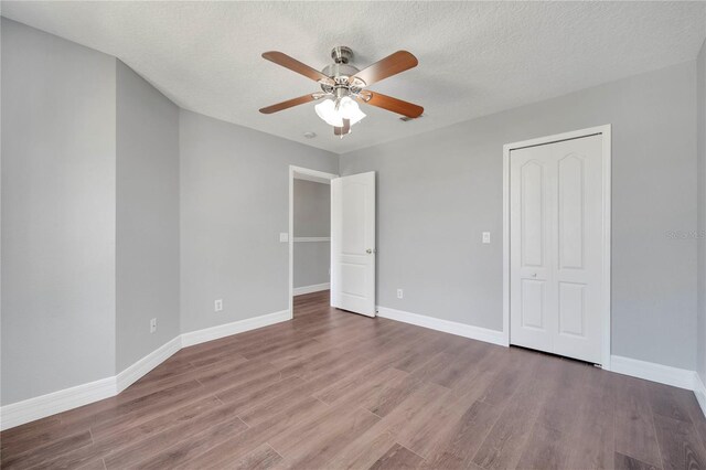 5768 Los Palma Vista Dr, Orlando, FL 32837 - unfurnished bedroom featuring wood finished floors, baseboards, a ceiling fan, a textured ceiling, and a closet