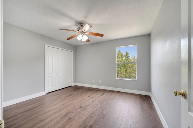 5768 Los Palma Vista Dr, Orlando, FL 32837 - unfurnished bedroom with baseboards, wood finished floors, a closet, a textured ceiling, and a ceiling fan