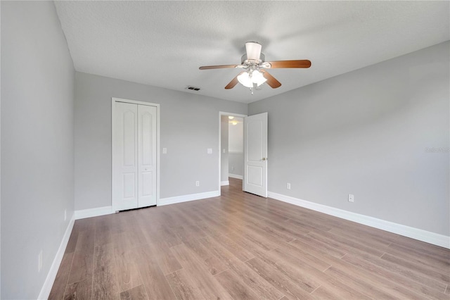 5768 Los Palma Vista Dr, Orlando, FL 32837 - unfurnished bedroom with light wood-style flooring, a closet, baseboards, and a textured ceiling