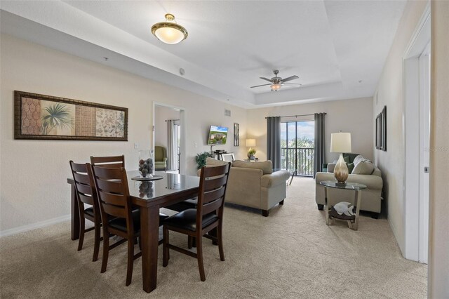 3060 Pirates Retreat Ct Unit 309, Kissimmee, FL 34747 - dining room featuring light colored carpet, a tray ceiling, ceiling fan, and baseboards