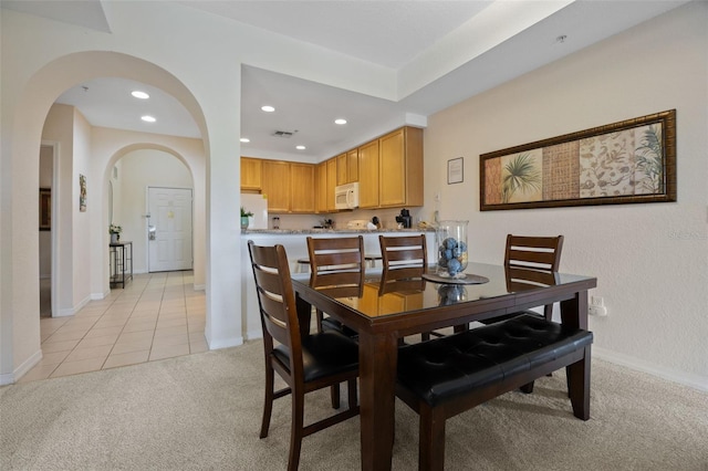 3060 Pirates Retreat Ct Unit 309, Kissimmee, FL 34747 - dining space with light colored carpet, arched walkways, recessed lighting, baseboards, and light tile patterned floors
