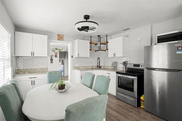 1024 Cohassett Ave, Lake Wales, FL 33853 - kitchen with appliances with stainless steel finishes, a sink, backsplash, open shelves, and white cabinetry