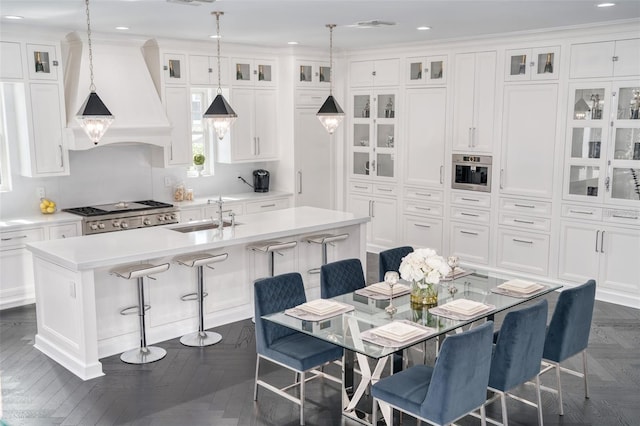 423 Arbor Cir, Celebration, FL 34747 - kitchen with a sink, premium range hood, a kitchen island with sink, white cabinetry, and recessed lighting