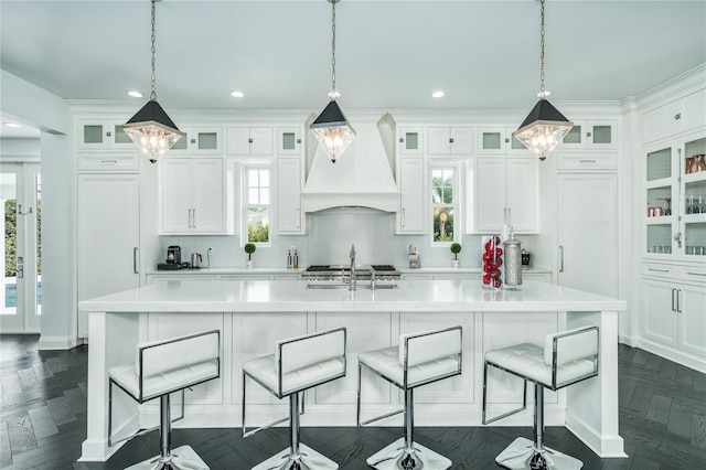 423 Arbor Cir, Celebration, FL 34747 - kitchen with custom range hood, light countertops, a center island with sink, white cabinets, and recessed lighting
