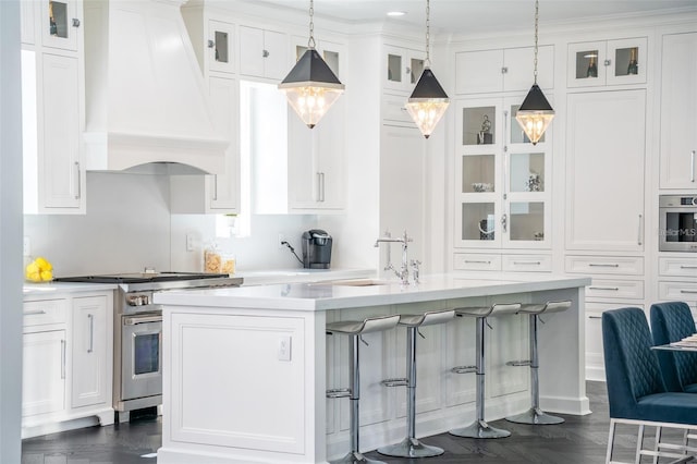 423 Arbor Cir, Celebration, FL 34747 - kitchen with stainless steel appliances, custom exhaust hood, a sink, a kitchen bar, and light countertops