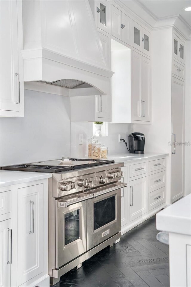 423 Arbor Cir, Celebration, FL 34747 - kitchen with double oven range, premium range hood, light countertops, white cabinets, and glass insert cabinets