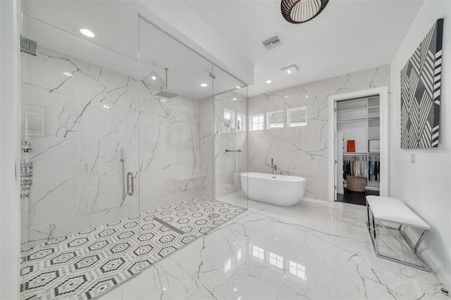 423 Arbor Cir, Celebration, FL 34747 - bathroom featuring a marble finish shower, marble tiled flooring, a freestanding tub, and a walk in closet
