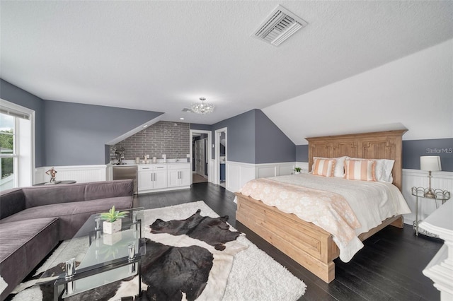 423 Arbor Cir, Celebration, FL 34747 - bedroom featuring wainscoting, dark wood finished floors, a textured ceiling, and a sink