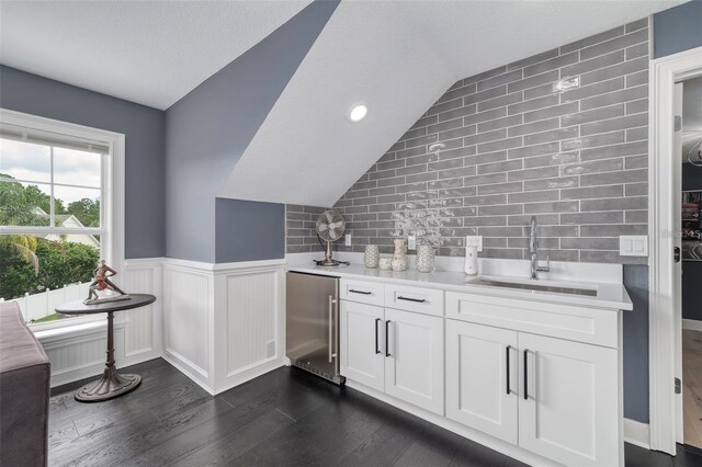 423 Arbor Cir, Celebration, FL 34747 - indoor wet bar with high end fridge, lofted ceiling, dark wood-style floors, backsplash, and wainscoting