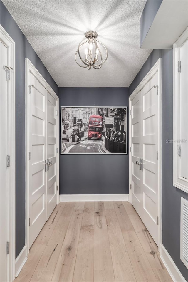 423 Arbor Cir, Celebration, FL 34747 - entryway featuring a chandelier, light wood-style flooring, a textured ceiling, and baseboards