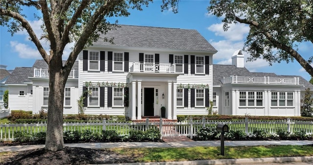 423 Arbor Cir, Celebration, FL 34747 - view of front of property featuring a balcony, a fenced front yard, roof with shingles, and a chimney