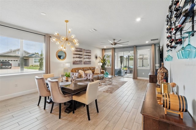 dining room featuring light wood finished floors, baseboards, a ceiling fan, recessed lighting, and a chandelier