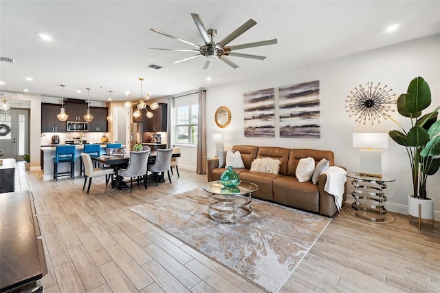 living area featuring light wood finished floors, recessed lighting, a ceiling fan, and baseboards