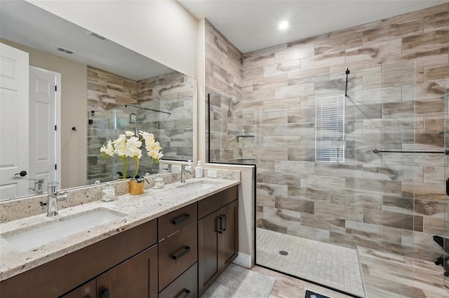 full bathroom featuring a stall shower and double vanity