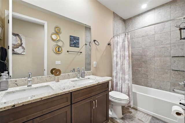 bathroom featuring toilet, shower / tub combo, and double vanity