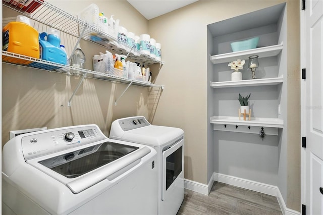 laundry area with washer and dryer, wood finished floors, and baseboards