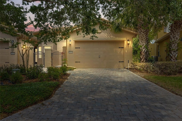 2376 Palm Tree Dr, Kissimmee, FL 34759 - view of front of home featuring decorative driveway, a garage, stucco siding, and a gate