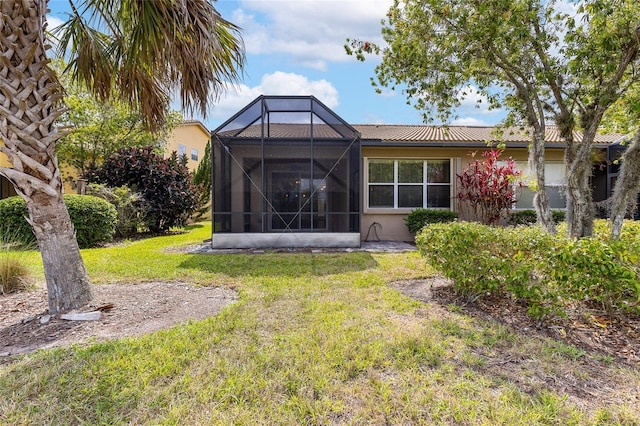 2376 Palm Tree Dr, Kissimmee, FL 34759 - back of house featuring a lawn and glass enclosure