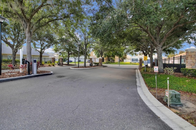 561 Lake Cummings Way, Lake Alfred, FL 33850 - view of asphalt street with a gate, curbs, a gated entry, and street lighting