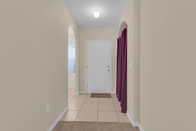 561 Lake Cummings Way, Lake Alfred, FL 33850 - hall featuring arched walkways, baseboards, and light tile patterned flooring