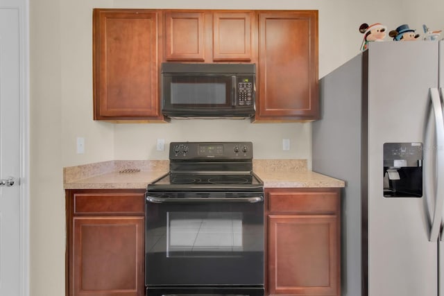 561 Lake Cummings Way, Lake Alfred, FL 33850 - kitchen featuring black appliances, light countertops, and brown cabinets