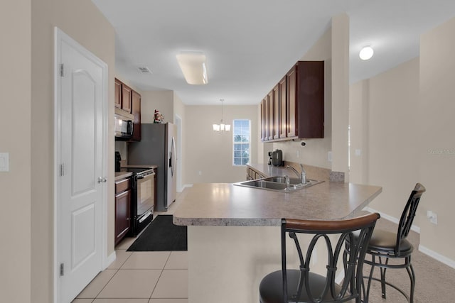 561 Lake Cummings Way, Lake Alfred, FL 33850 - kitchen featuring electric range, a sink, a peninsula, a breakfast bar, and light countertops