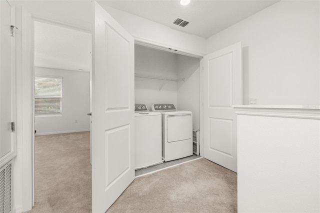 laundry area with light colored carpet, washer and clothes dryer, and baseboards