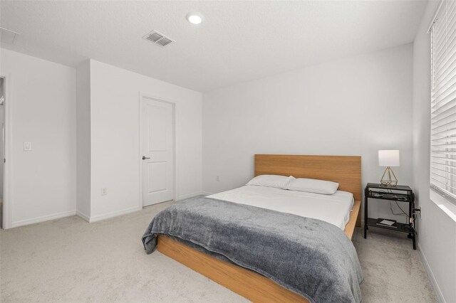 carpeted bedroom featuring multiple windows and baseboards