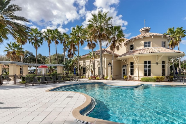 community pool featuring fence and a patio area