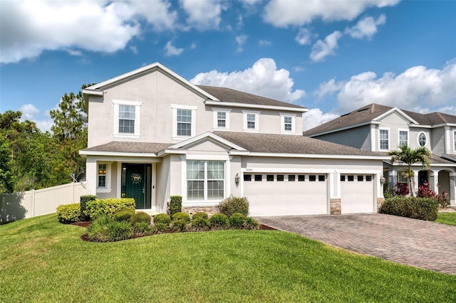 traditional home with a garage, stone siding, driveway, and stucco siding