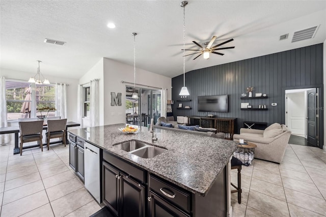 kitchen featuring a sink, vaulted ceiling, open floor plan, a ceiling fan, and a kitchen island with sink
