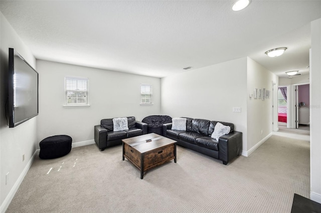 living area with light carpet and baseboards