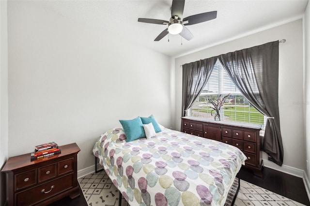 bedroom with baseboards, a ceiling fan, and light wood-style floors