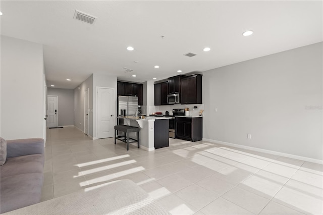 352 Smugglers Way, Apopka, FL 32712 - kitchen with appliances with stainless steel finishes, open floor plan, a breakfast bar, light tile patterned flooring, and recessed lighting