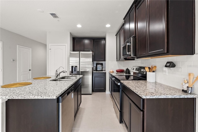 352 Smugglers Way, Apopka, FL 32712 - kitchen featuring stainless steel appliances, a sink, decorative backsplash, dark brown cabinetry, and recessed lighting