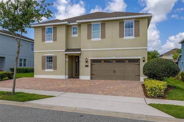 420 Burma St, Kissimmee, FL 34747 - view of front of home with stucco siding, decorative driveway, and a garage