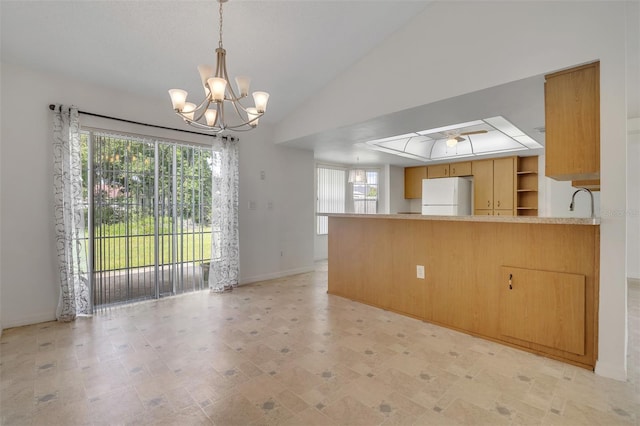 14091 SW 32nd Terrace Rd, Ocala, FL 34473 - kitchen featuring freestanding refrigerator, a chandelier, a peninsula, light countertops, and lofted ceiling