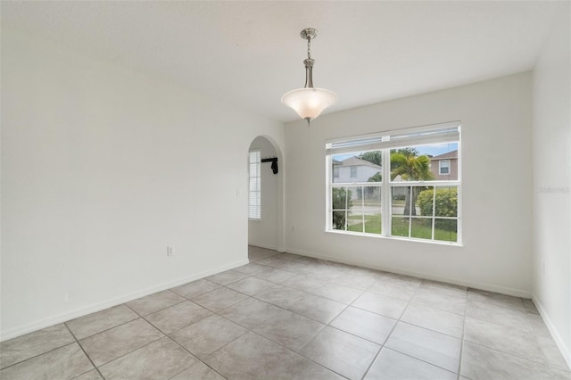 4630 Elena Way, Melbourne, FL 32934 - empty room featuring arched walkways, light tile patterned floors, and baseboards