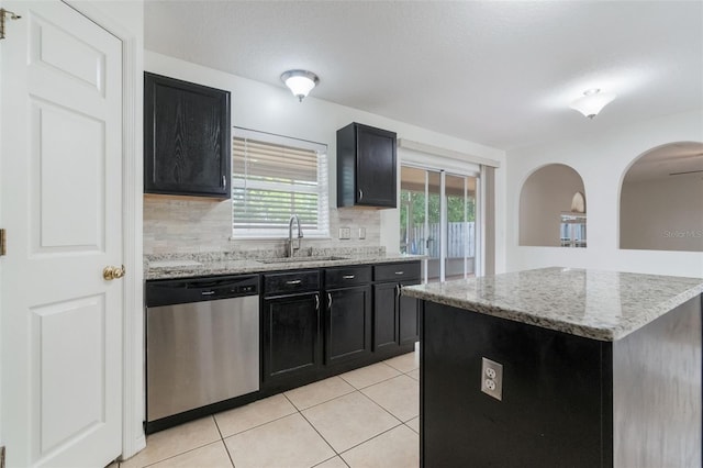 4630 Elena Way, Melbourne, FL 32934 - kitchen with dishwasher, a sink, dark cabinets, light tile patterned floors, and tasteful backsplash