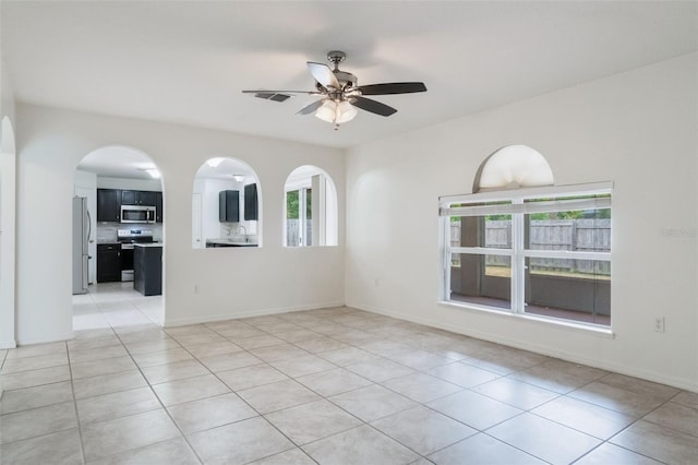 4630 Elena Way, Melbourne, FL 32934 - empty room featuring light tile patterned floors, ceiling fan, and arched walkways