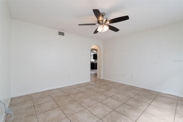 4630 Elena Way, Melbourne, FL 32934 - empty room featuring arched walkways, a ceiling fan, light tile patterned flooring, and baseboards