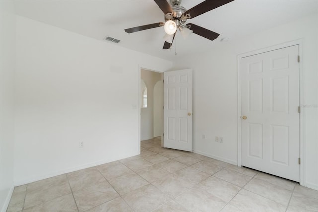 4630 Elena Way, Melbourne, FL 32934 - unfurnished bedroom with arched walkways, light tile patterned floors, and a ceiling fan