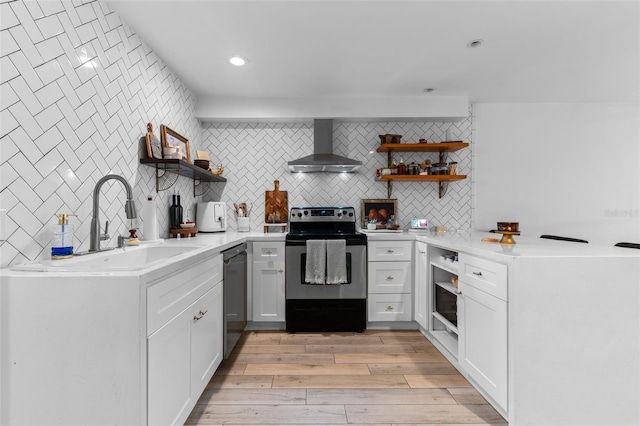 5234 Eaglesmere Dr Unit D04, Orlando, FL 32819 - kitchen with open shelves, wall chimney range hood, appliances with stainless steel finishes, tasteful backsplash, and light wood-style flooring