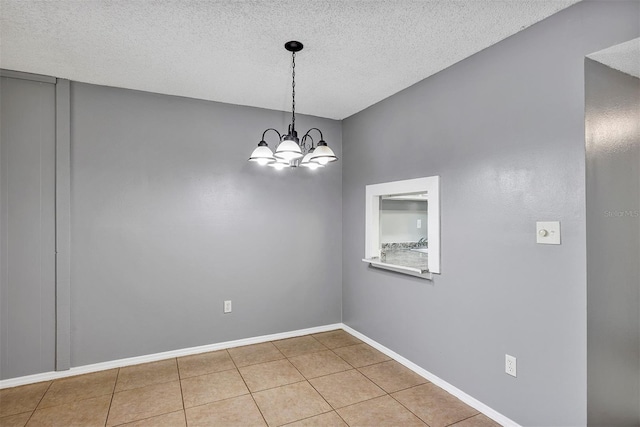 2864 N Powers Dr Unit 150, Orlando, FL 32818 - tiled spare room with a textured ceiling, a chandelier, and baseboards