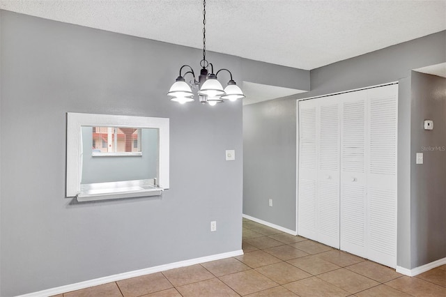 2864 N Powers Dr Unit 150, Orlando, FL 32818 - unfurnished dining area featuring tile patterned flooring, a chandelier, baseboards, and a textured ceiling
