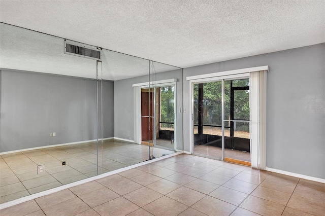 2864 N Powers Dr Unit 150, Orlando, FL 32818 - unfurnished bedroom featuring access to exterior, tile patterned flooring, a textured ceiling, and baseboards