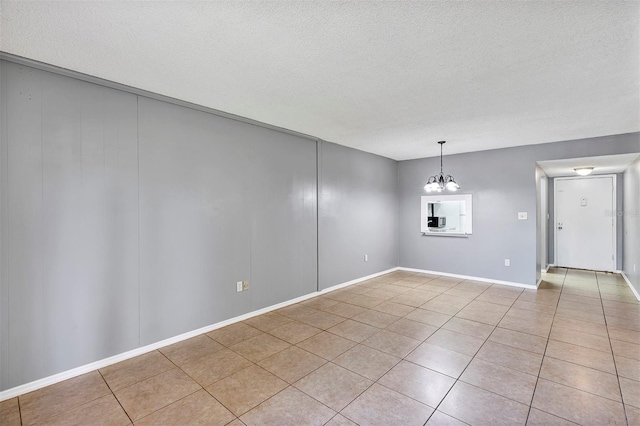 2864 N Powers Dr Unit 150, Orlando, FL 32818 - unfurnished dining area featuring a chandelier, light tile patterned floors, a textured ceiling, and baseboards